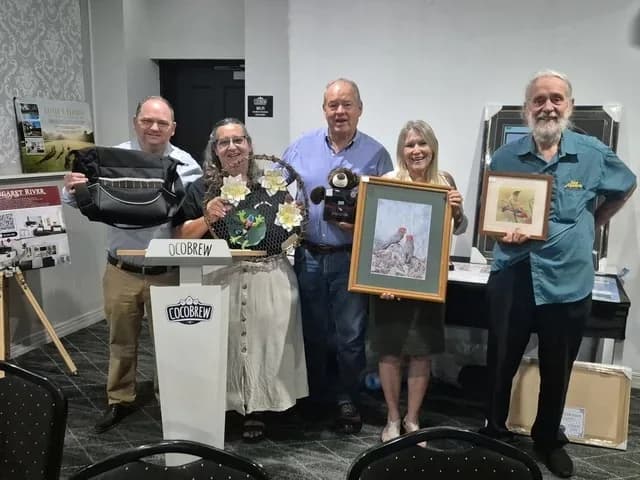 Volunteers and supporters holding silent auction prizes